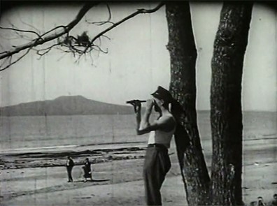 Man on beachfront in a scene from A Takapuna Scandal (1928)