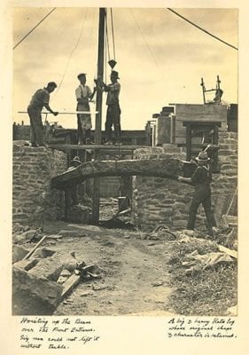 Photo by J. W. Chapman-Taylor (ca.1930) of workers hoisting the beam over the front entrance of the home of C. A. Wilkinson Esq.