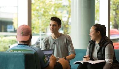 Three students seated in discussion